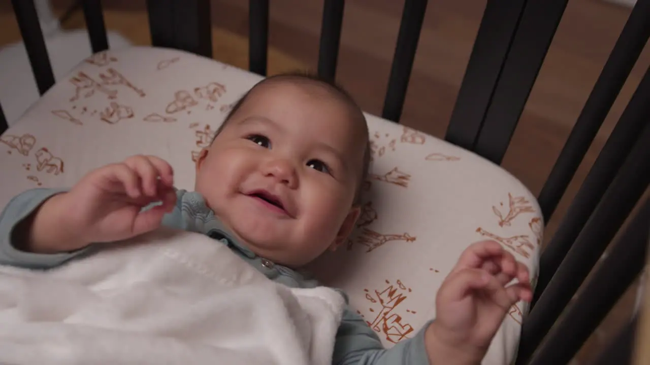 Cute baby laughing and smiling in crib