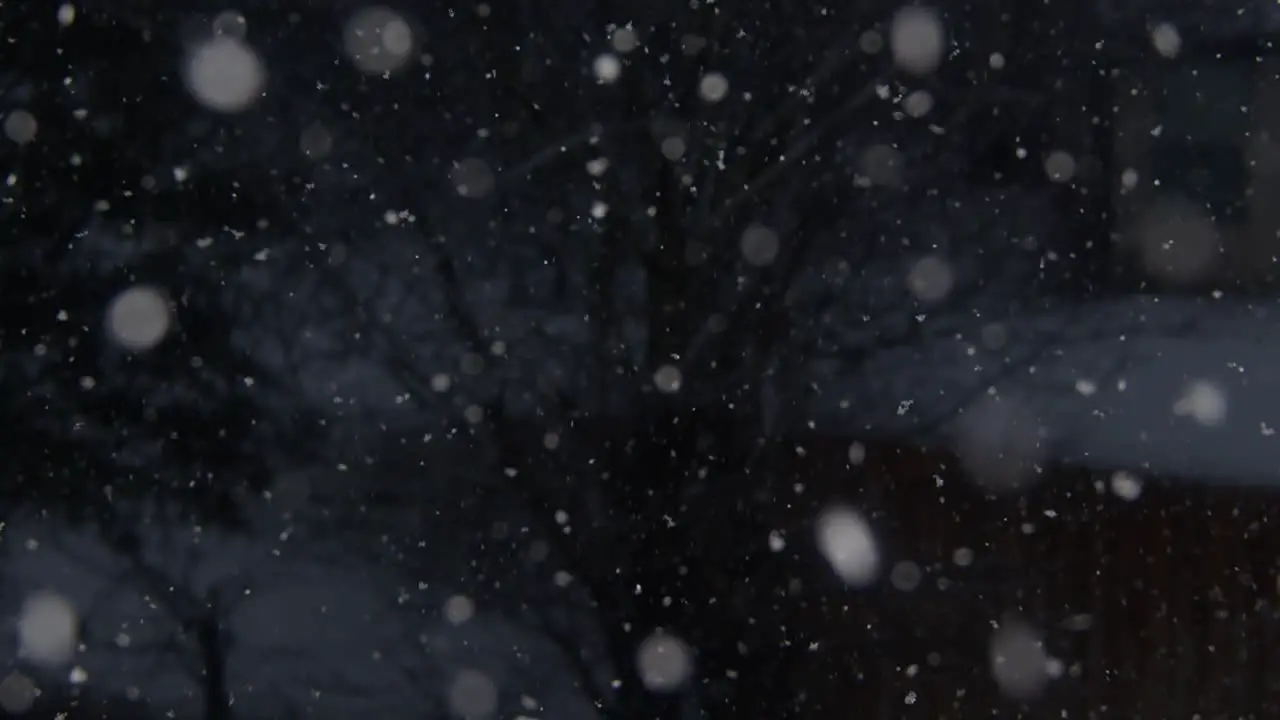 January snowfall in the evening with the camera panning down to focus on a snow-covered wooden fence