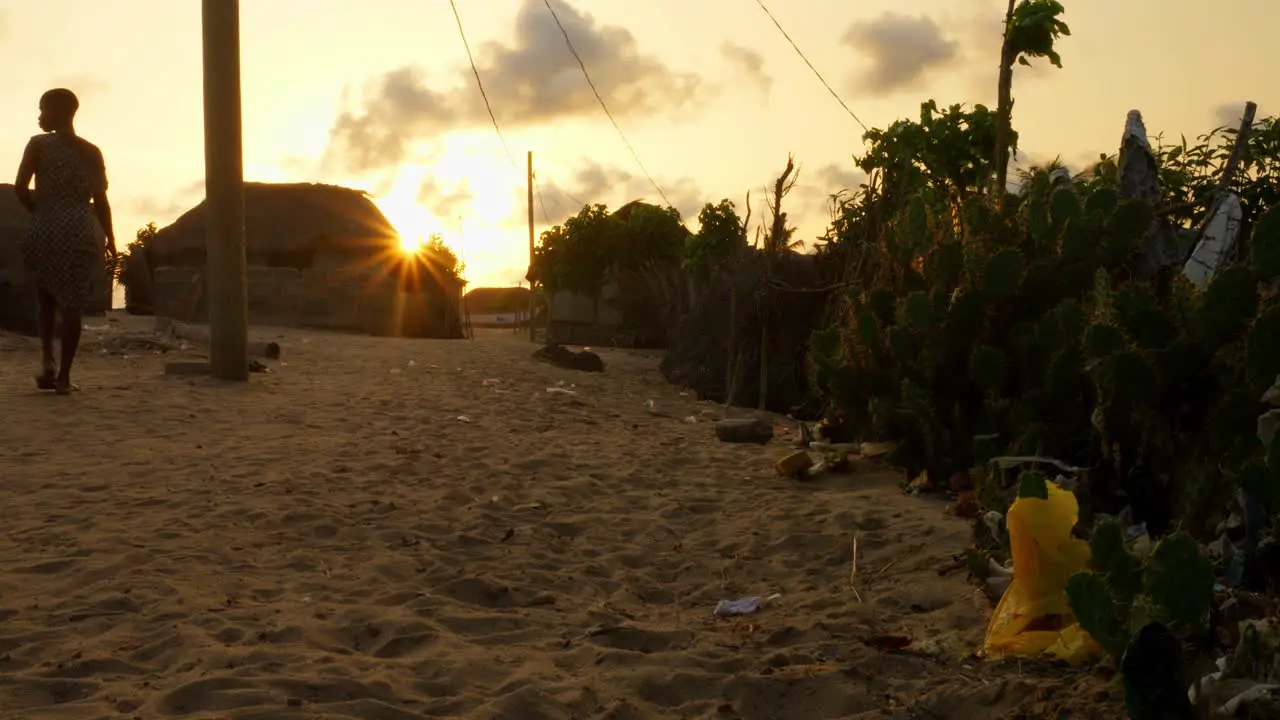 trash plastic bag pollution on sandy tropical beach at sunset in rural village of africa