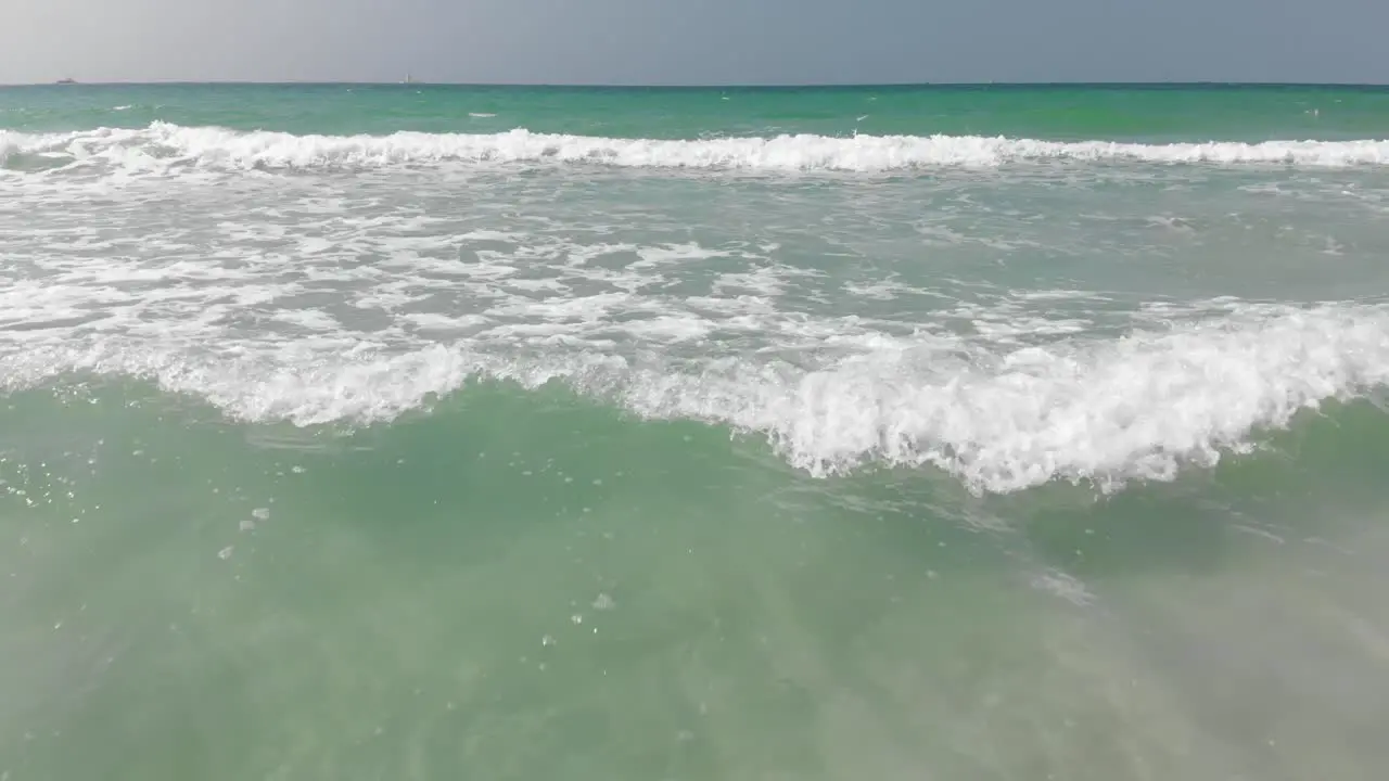 Drone Camera follows the ocean waves crashing and foaming