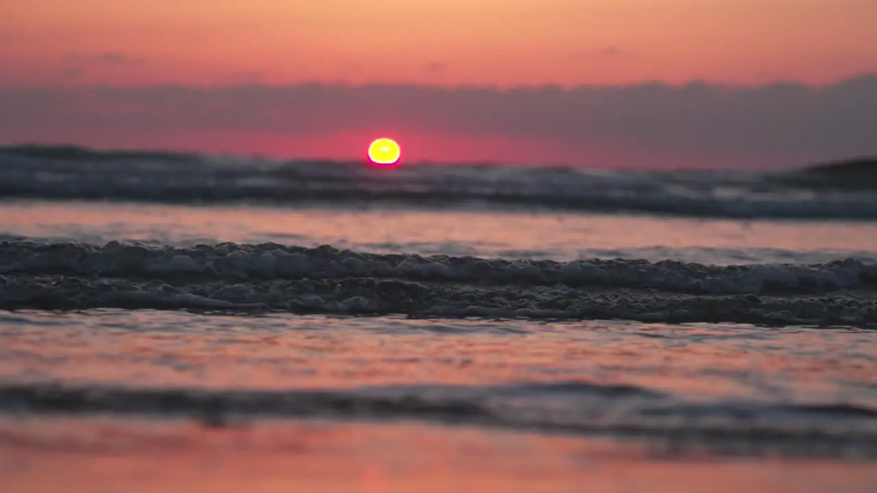 Close up of Beautiful sunset waves crashing on beach in summer warm golden hour slow motion peaceful scene to relax