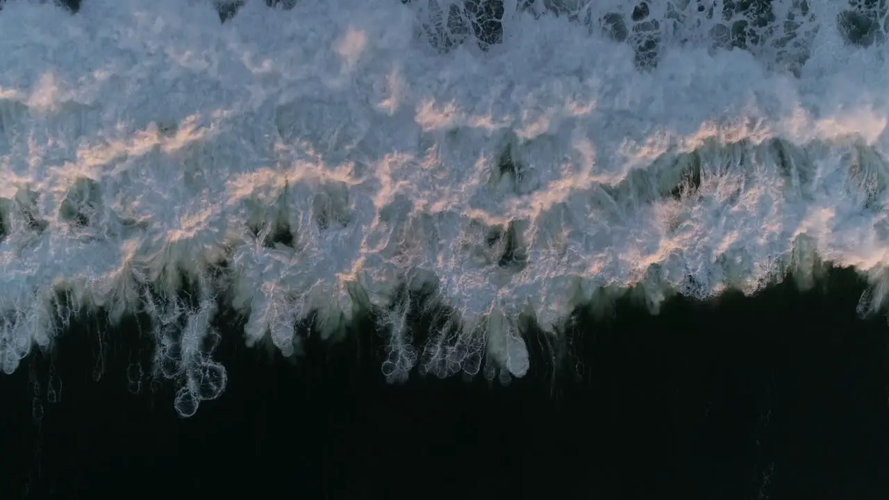 Overhead aerial drone of ocean wave on dark sea