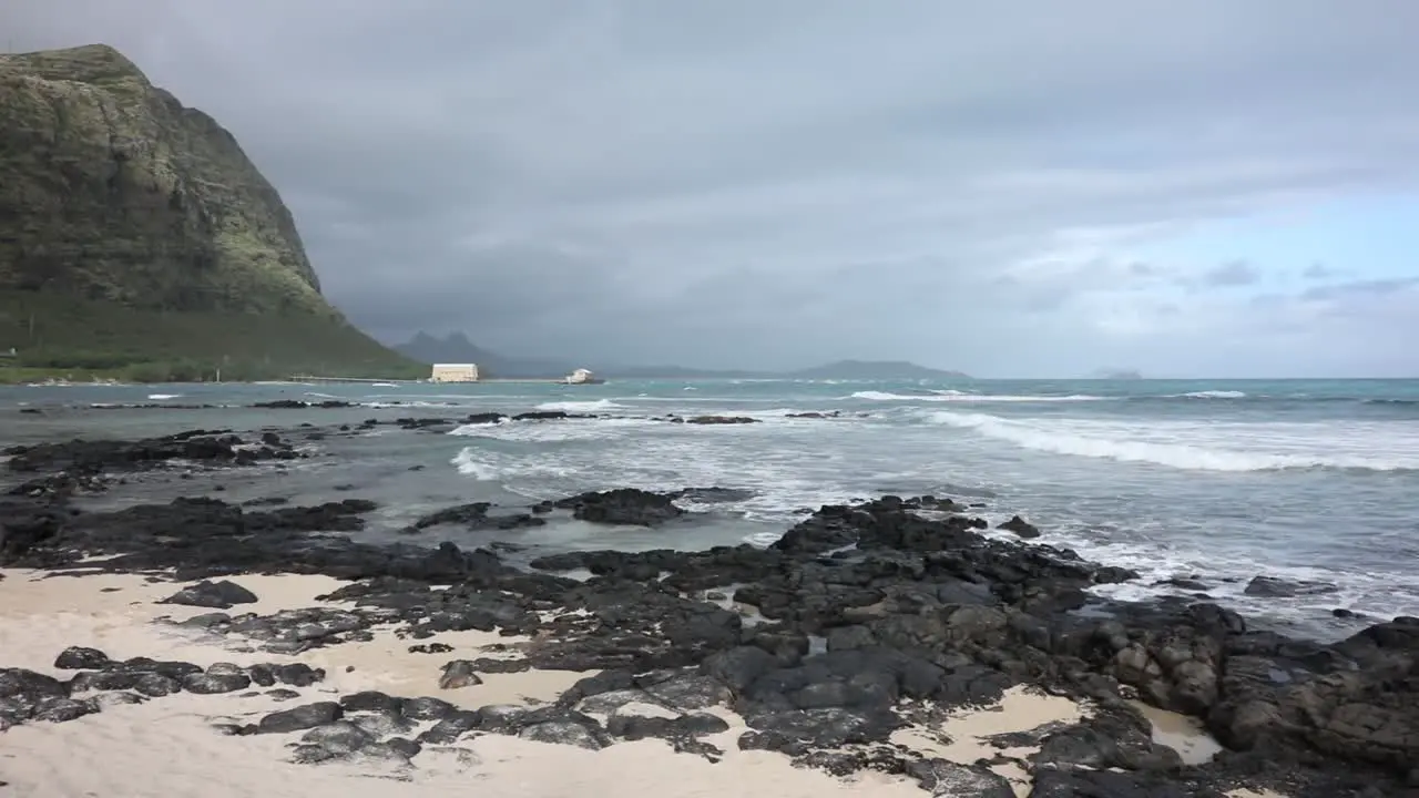 Slow pan across sand and ocean waves