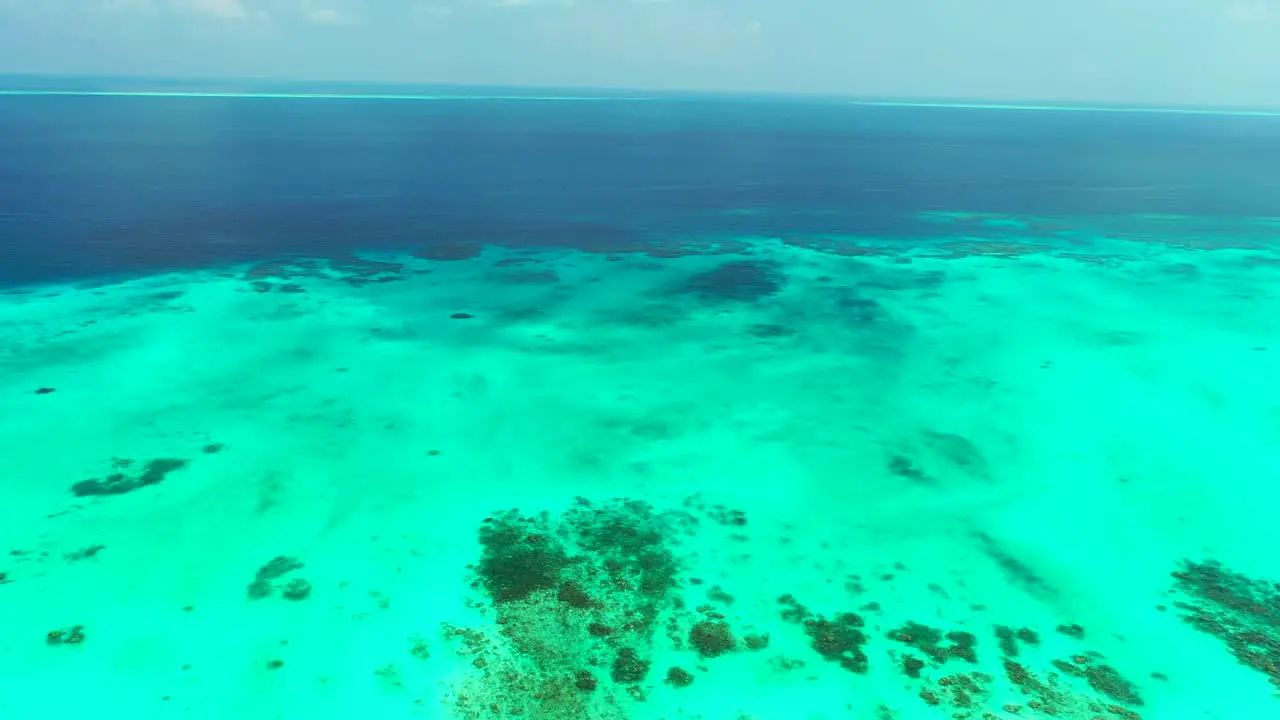 Ocean texture with deep blue and turquoise water colors abstract natural patterns of coral reef on white sandy bottom under clear water in Caribbean