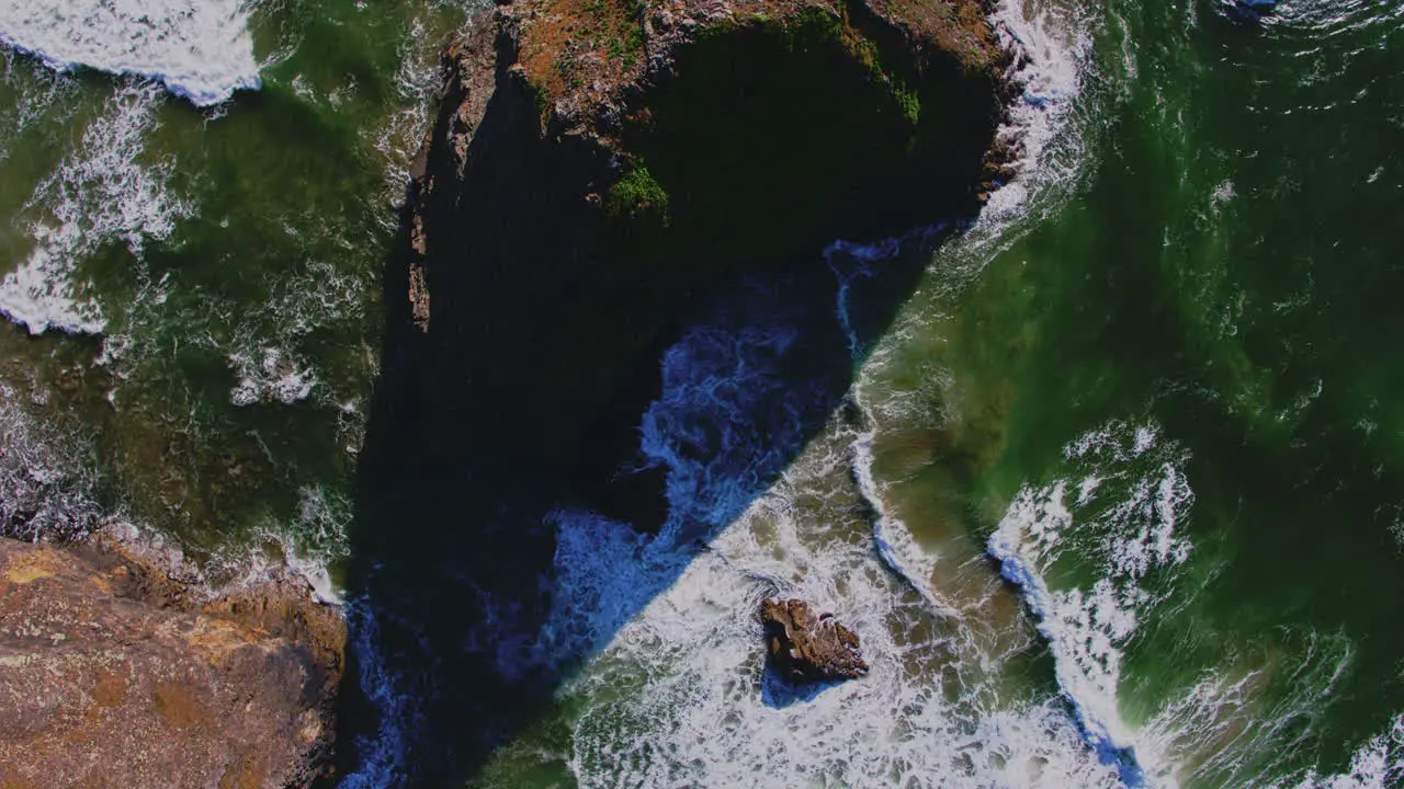 Aerial rising directly above ocean rock wave patterns and textures