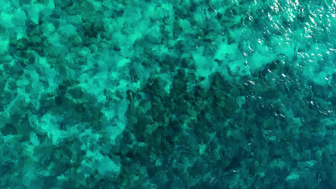 Clear ocean water texture above coral reef heads high angle panoramic aerial static