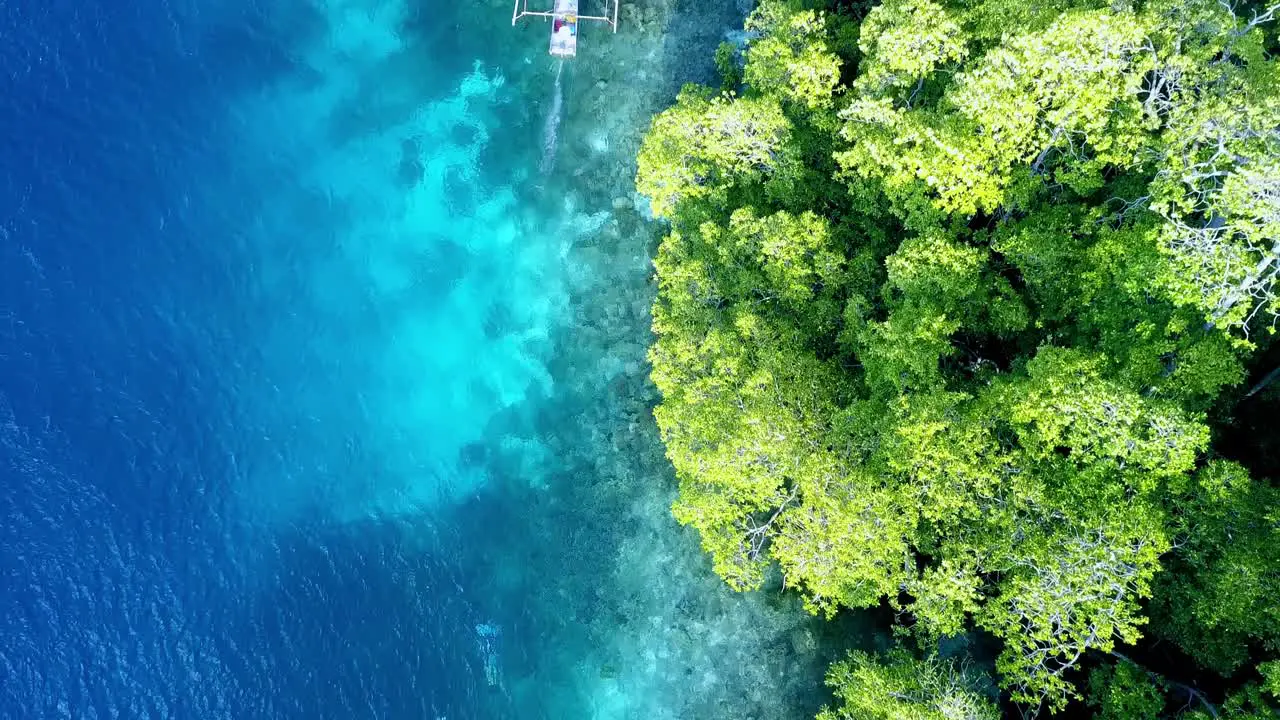 Young man ocean gliding with a Subwing in Raja Ampat Indonesia island shore Aerial top view tracking shot