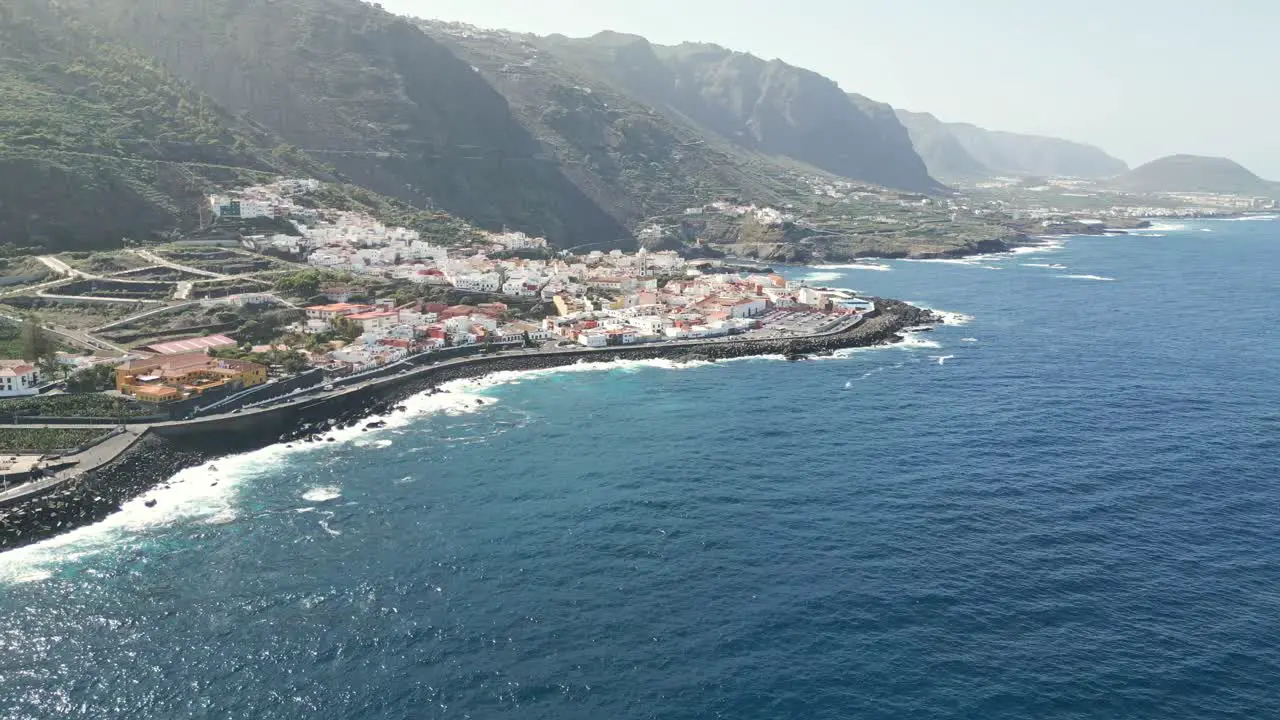 Drone push in to reveal quaint ocean view town near Port Garachico Tenerife Spain