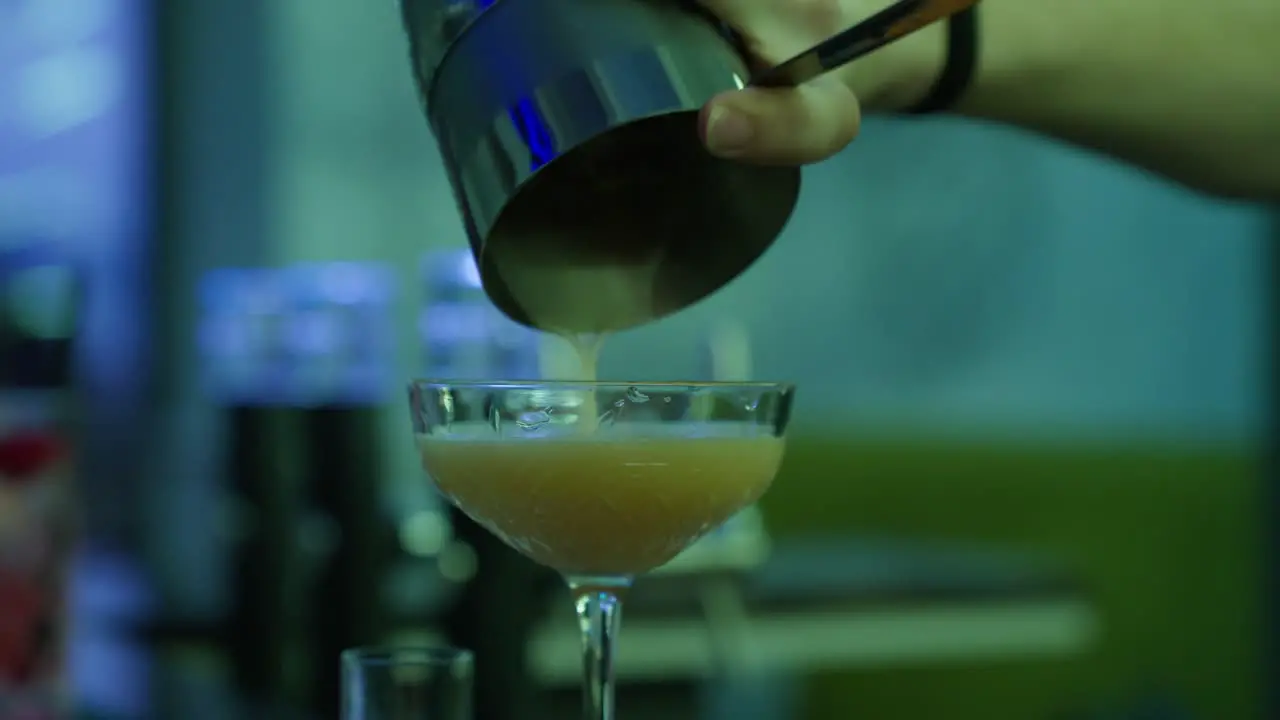 Barkeeper pours Drink into Cocktail Glass Nightlife