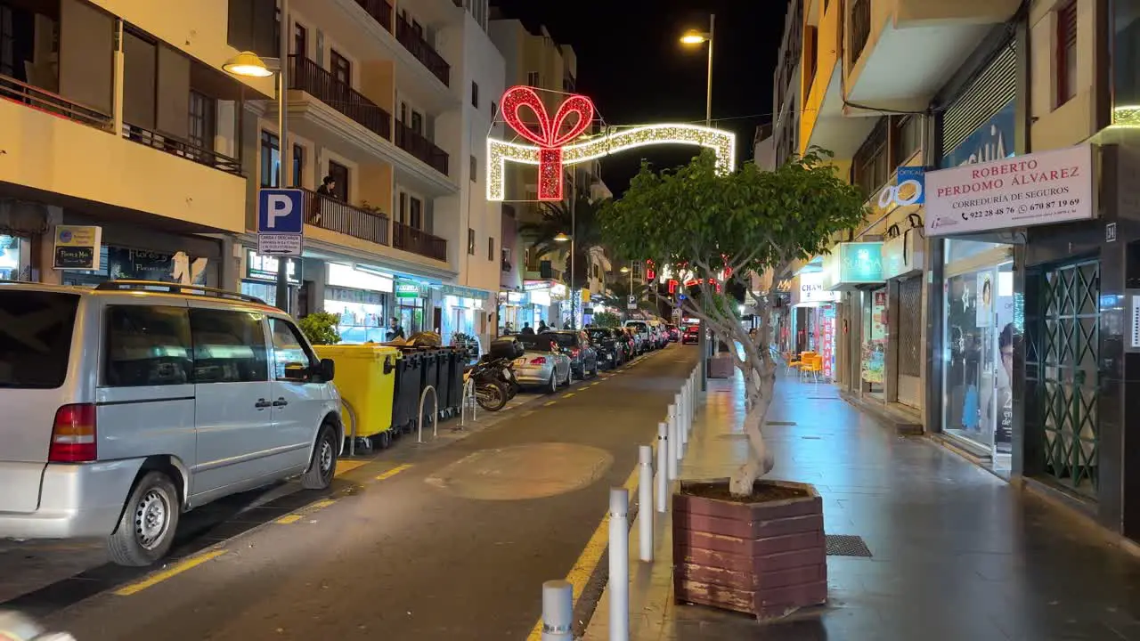 Los Cristianos street in Tenerife at night cars passing on main road Spain