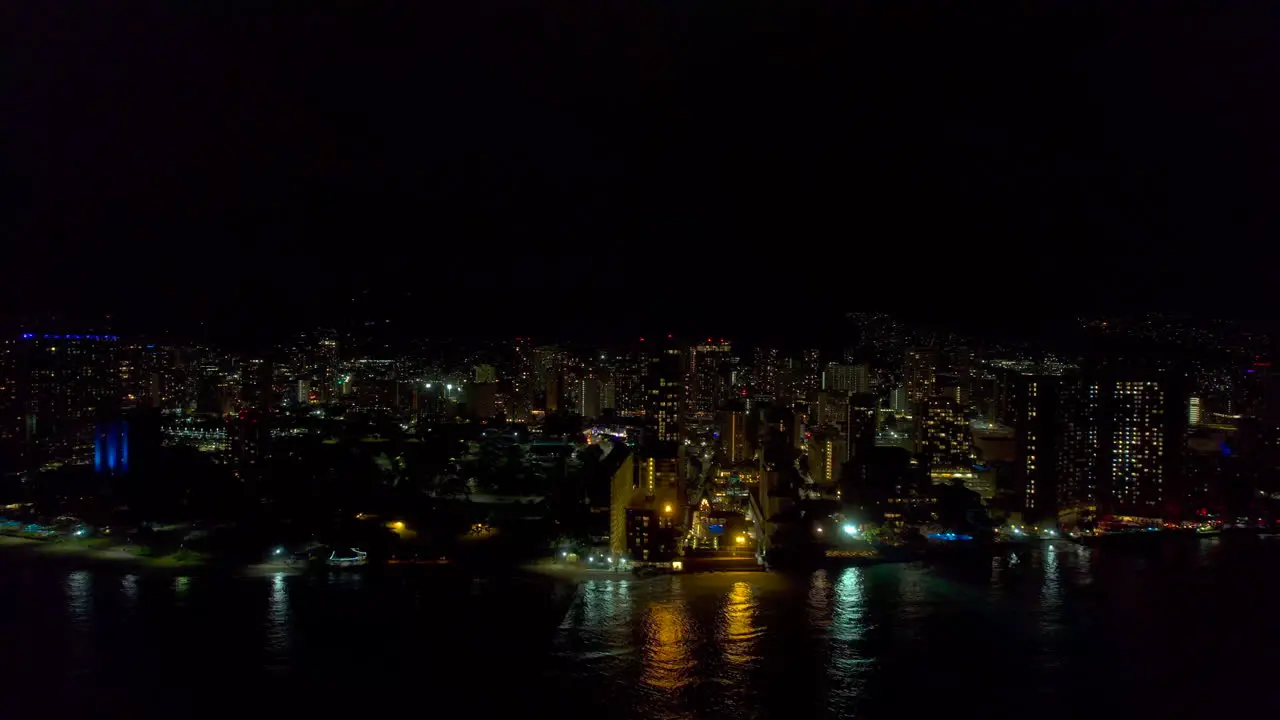 Right to left aerial view of Honolulu Hawaii at night