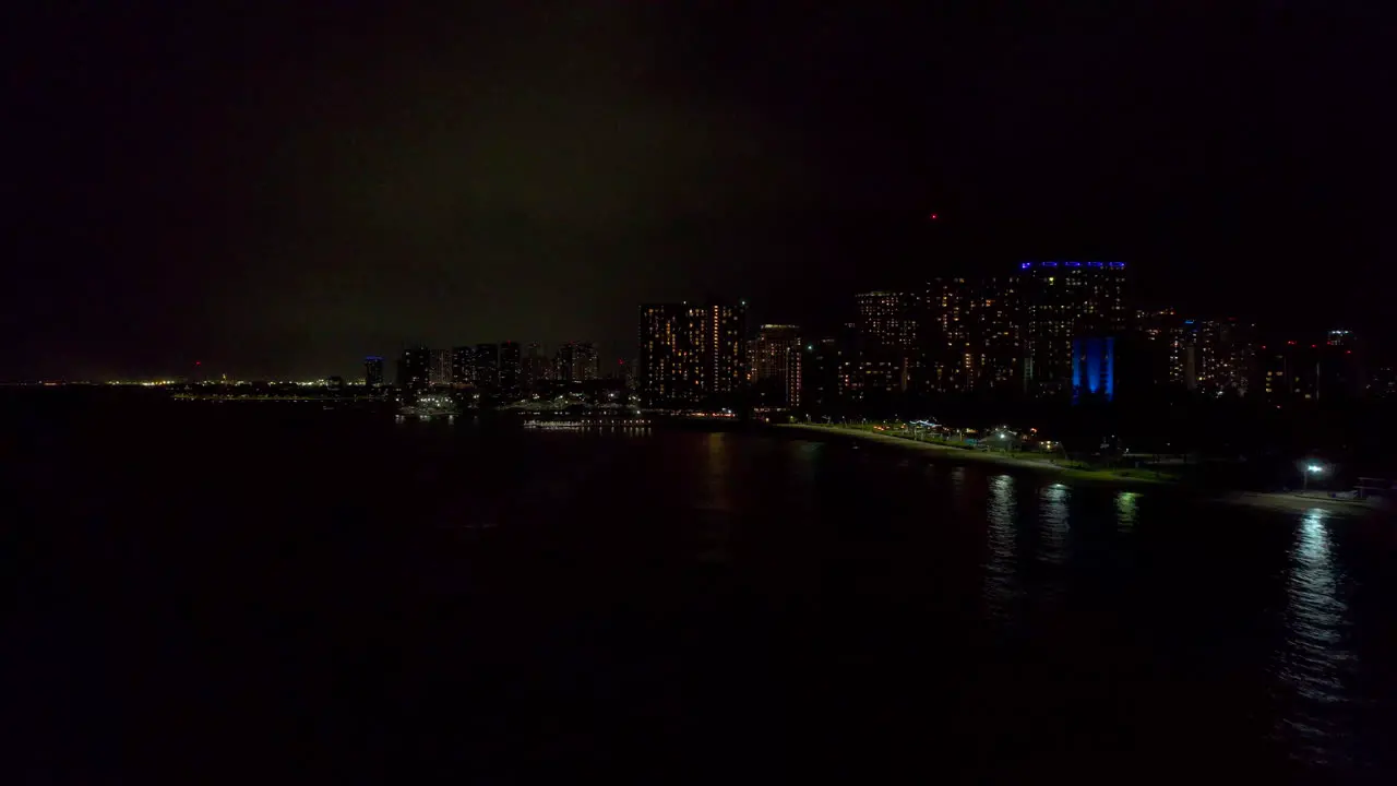 Nighttime aerial view up the northwest coastline of Honolulu Hawaii