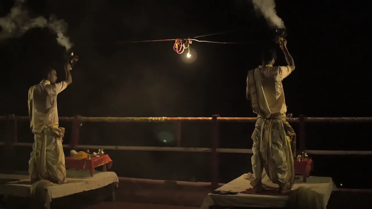 Panning Shot of Men Burning Incense at Night