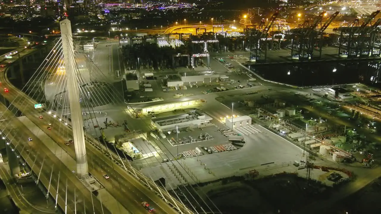 Aerial fly by over bridge in Long Beach California | Shipping port in background | Night time