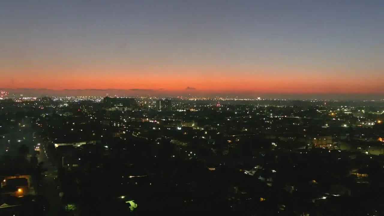 Aerial flyby of fireworks exploded over city skyline | beautiful sunset in background