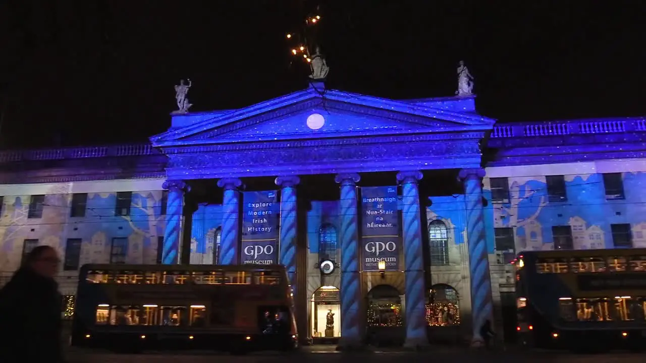 General post office with people and public transport at night time December 1st