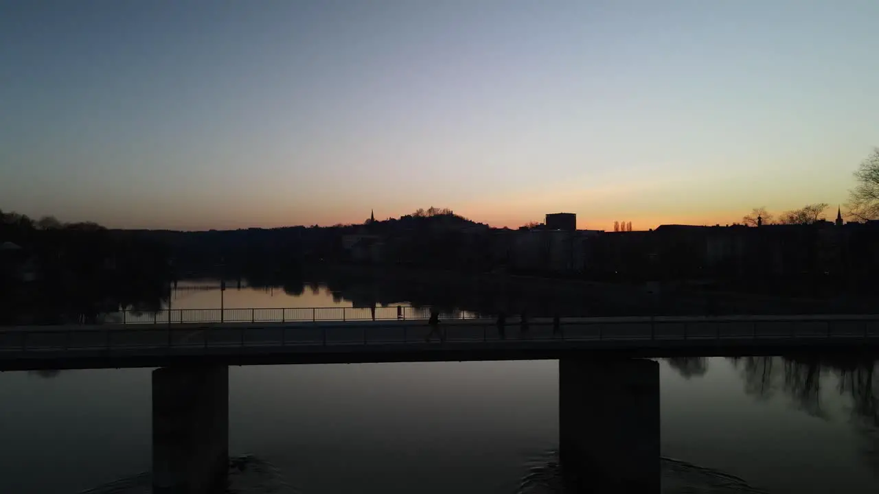 Hiker walking a bridge over a river at sunset in Passau Germany