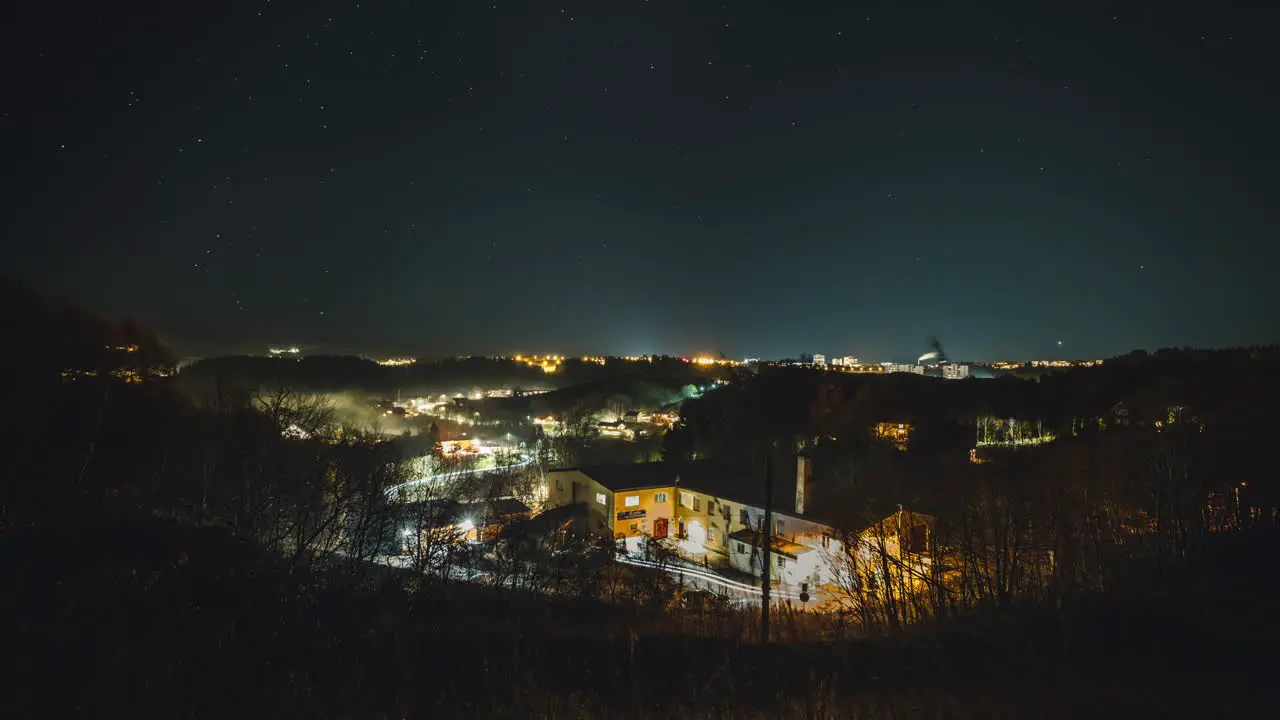 A evening timelapse of a city showing lights dancing and stars moving in the sky