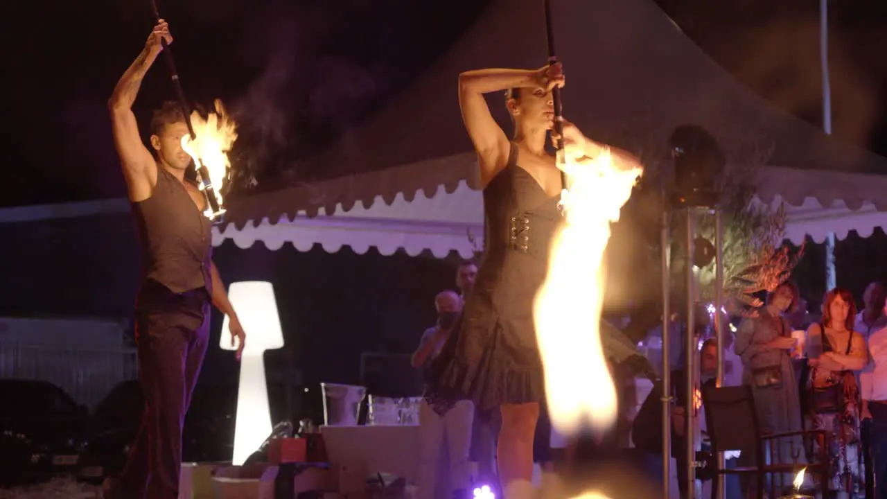 Fiery Jugglers' Nocturnal Ballet Enchanting Display of Flaming Baton Mastery