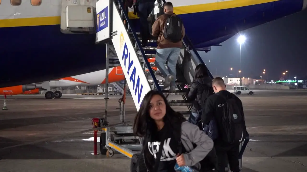 People boarding a plane in the middle of the night