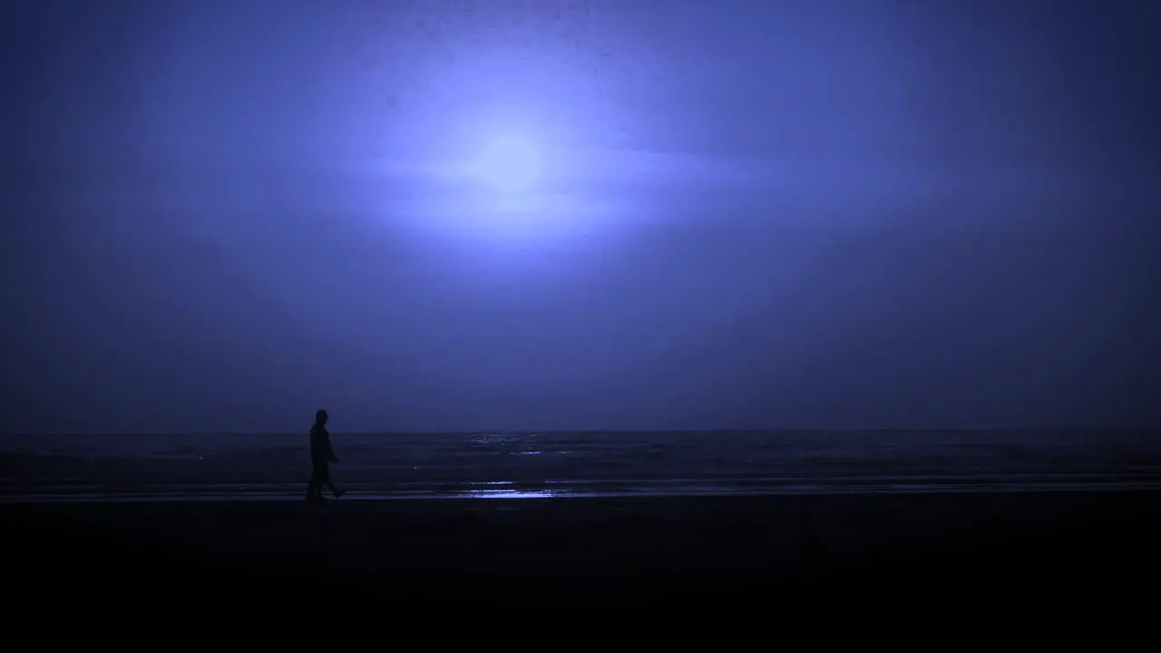 Full moon at beach silhouette of two man walking on the beach blue night India