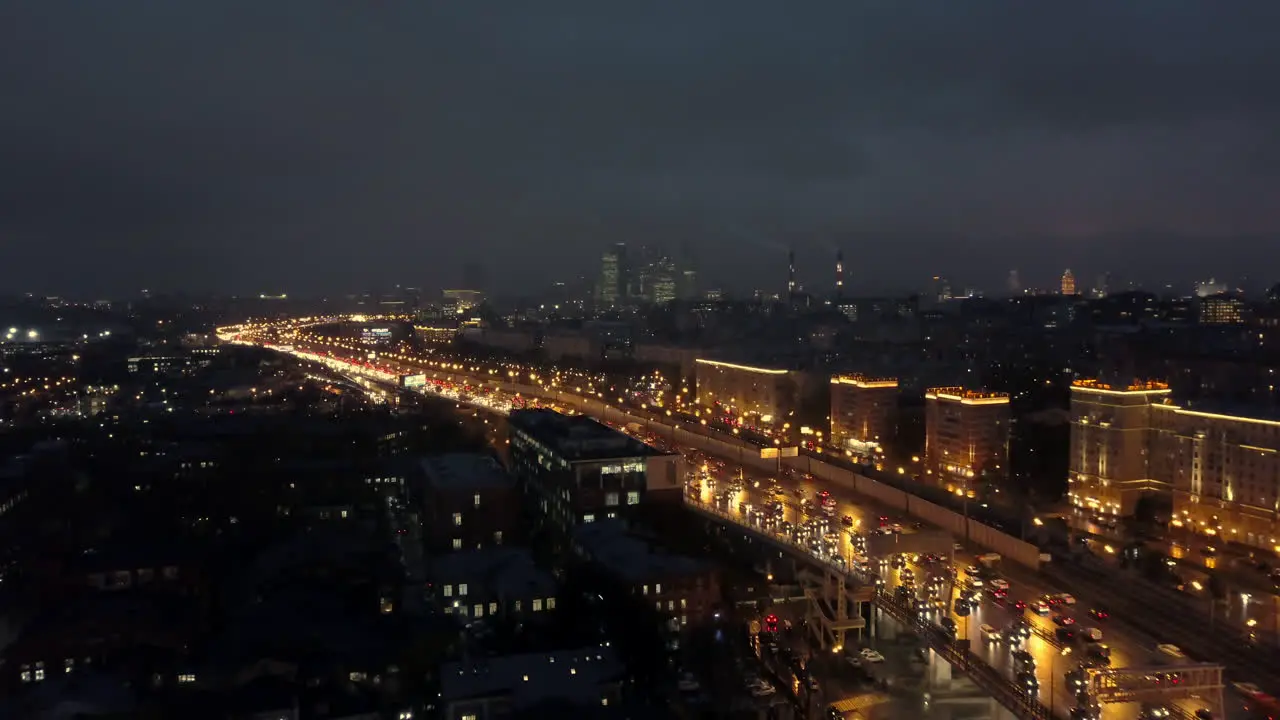 An aerial view of a night city with a busy highway