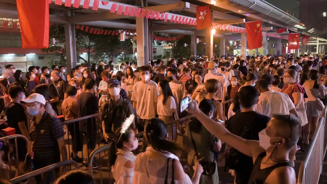 Chinese vsitors queue patiently in line to enter a nighttime lantern show which symbolizes prosperity and good fortune at the Wong Tai Sin temple during the Mid-Autumn Festival 