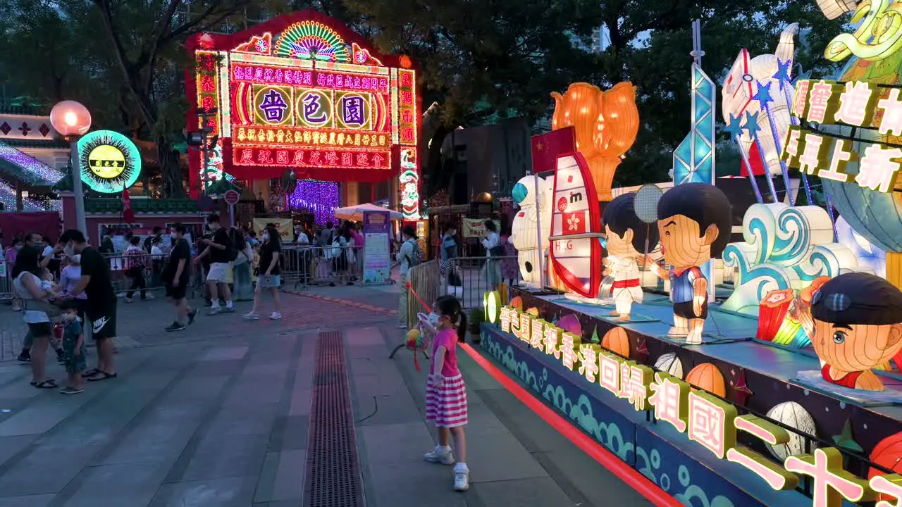 Visitors and residents pose for photos in front of a lantern installation show which symbolizes prosperity and good fortune during the Mid-Autumn Festival also called Mooncake Festival