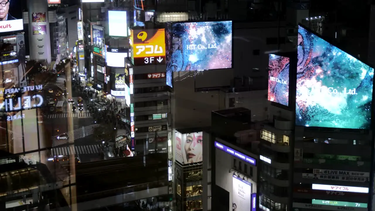 A view from above of building top LED advertising displays at night in the iconic Shibuya at night