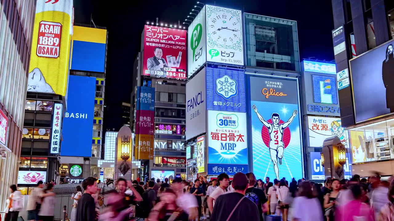 Night Time lapse of busy crowds and Illuminated signboards at Ebisubashi Bridge On The Dotonbori Canal Osaka Japan