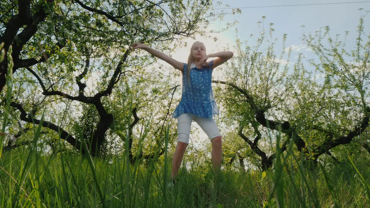 Funny Girl Dances In The Apple Orchard In The Sun