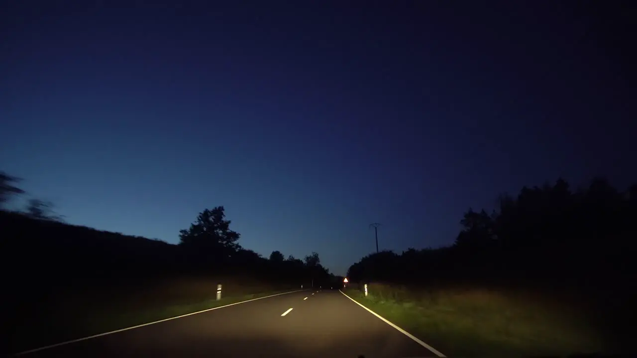 A POV shot driving through a country lane at night