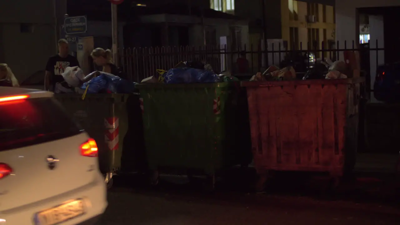 City street with full waste containers night view