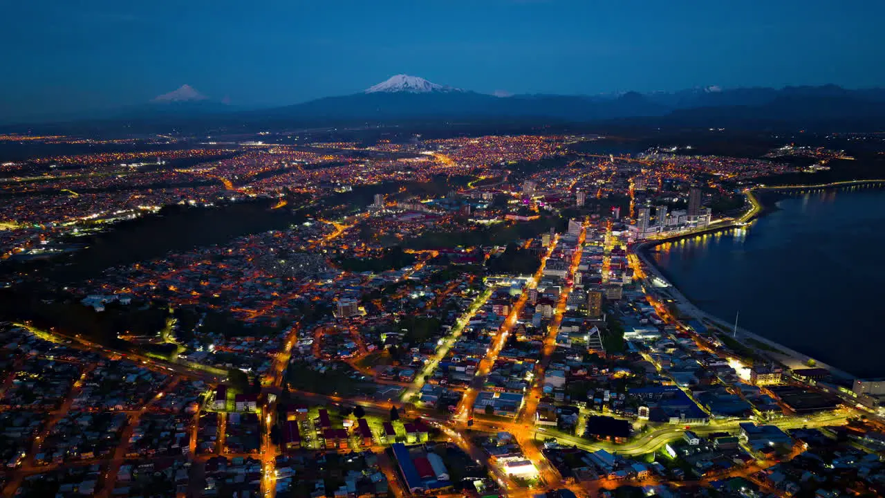 Aerial Timelapse over Puerto Montt city at dawn showing the evening lights over the costal city