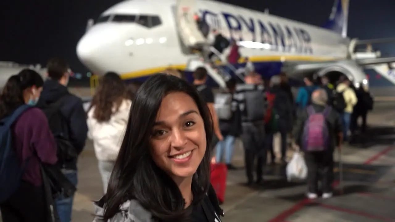 Woman standing in front of a plane ready to travel