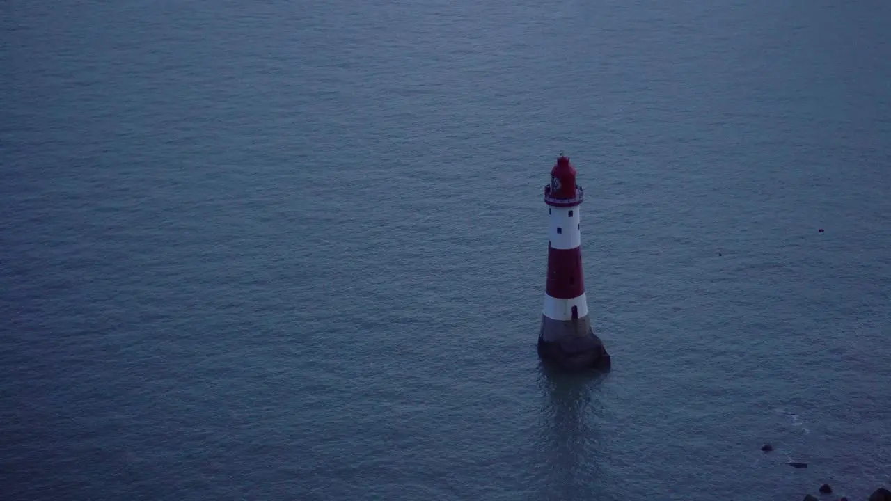 Red and White Lighthouse with Flashing Light After Dusk