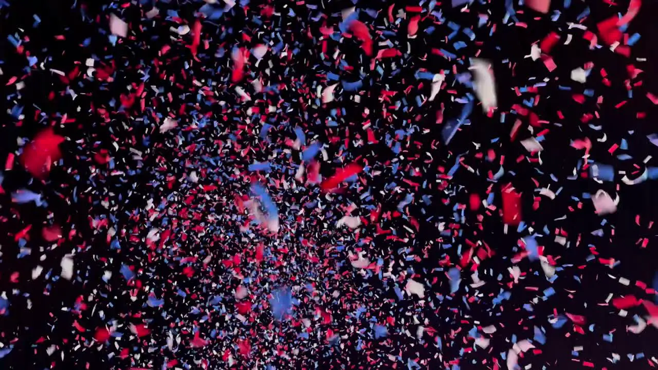 Thousands of red white and blue confetti pieces falling from the night sky background