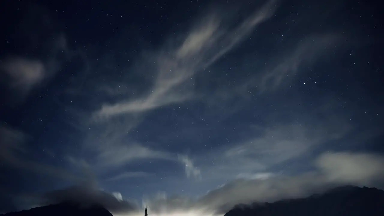 timelapse of Hawaiian night sky with brilliant bright stars and fluffy white clouds over the Koolau mountain rage on oahu hawaii