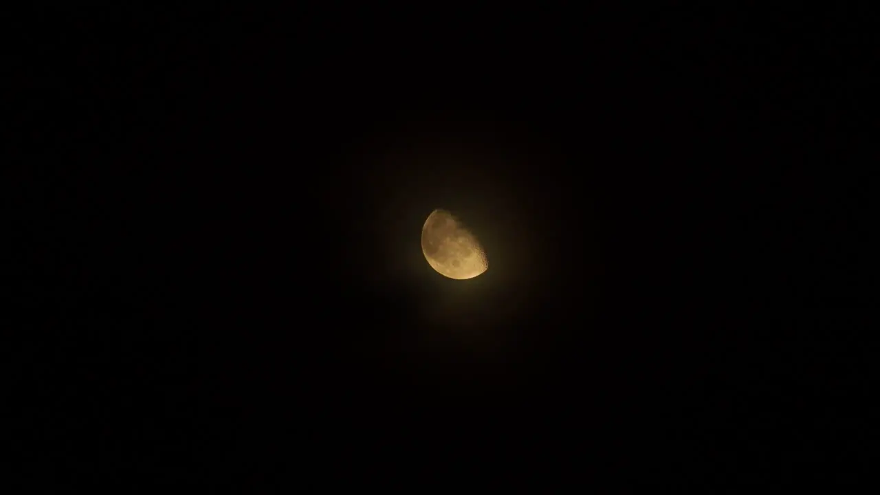 Clouds slowly passing in front of a bright moon at night