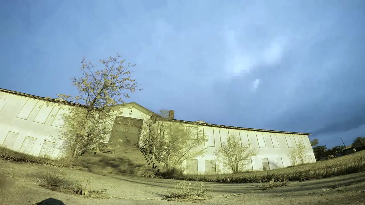 NIGHT LAPSE Moon and clouds moving fast behind a big abandoned building