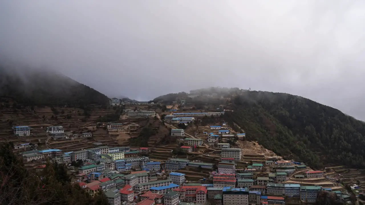 A high angle view of Namche Bazaar with a time-lapse of clouds rolling over the town and the mountain ridges