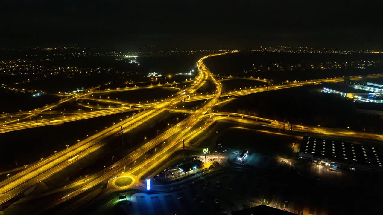 Aerial drone Hyperlapse of highway intersection at night with cars and traffic