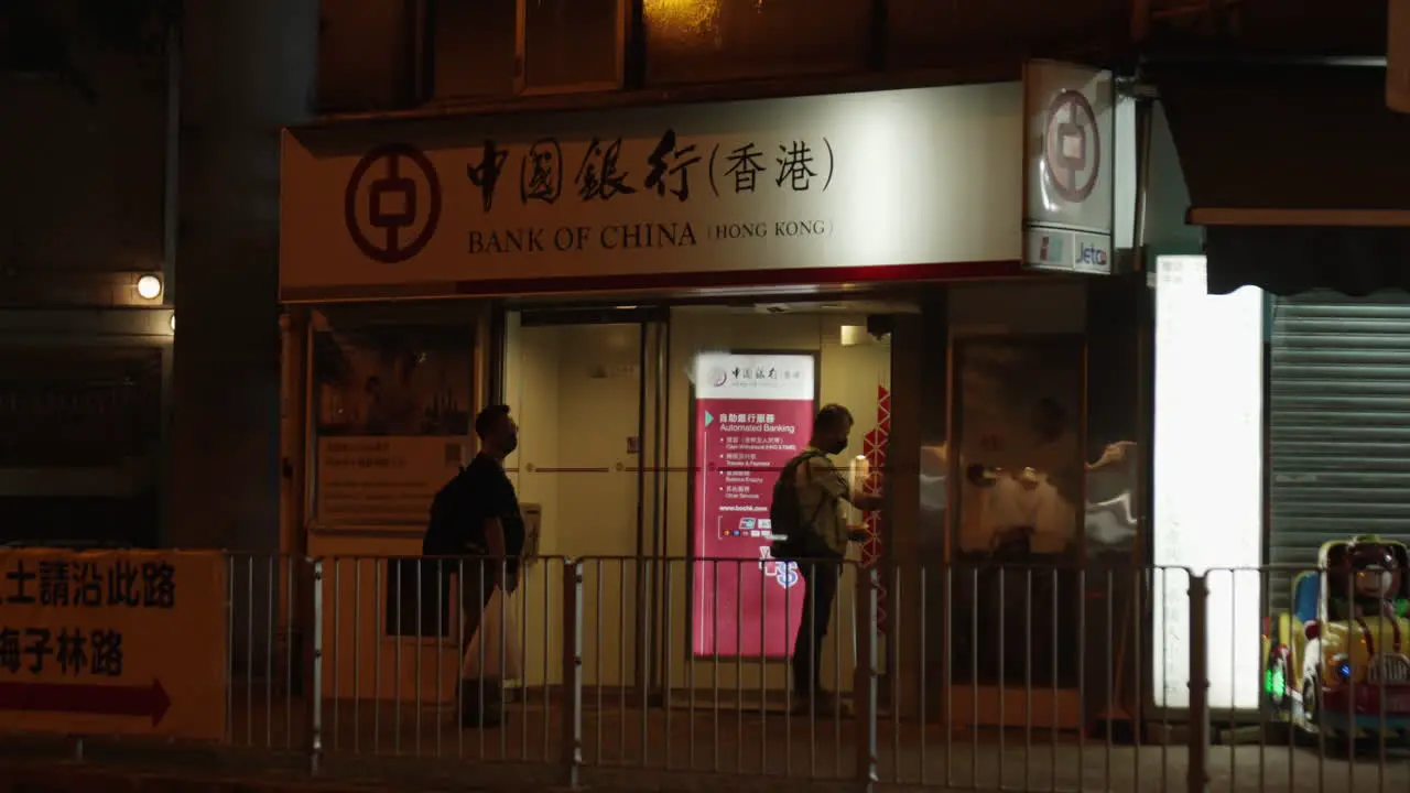 Static shot of a man taking money from an ATM machine in Hong Kong