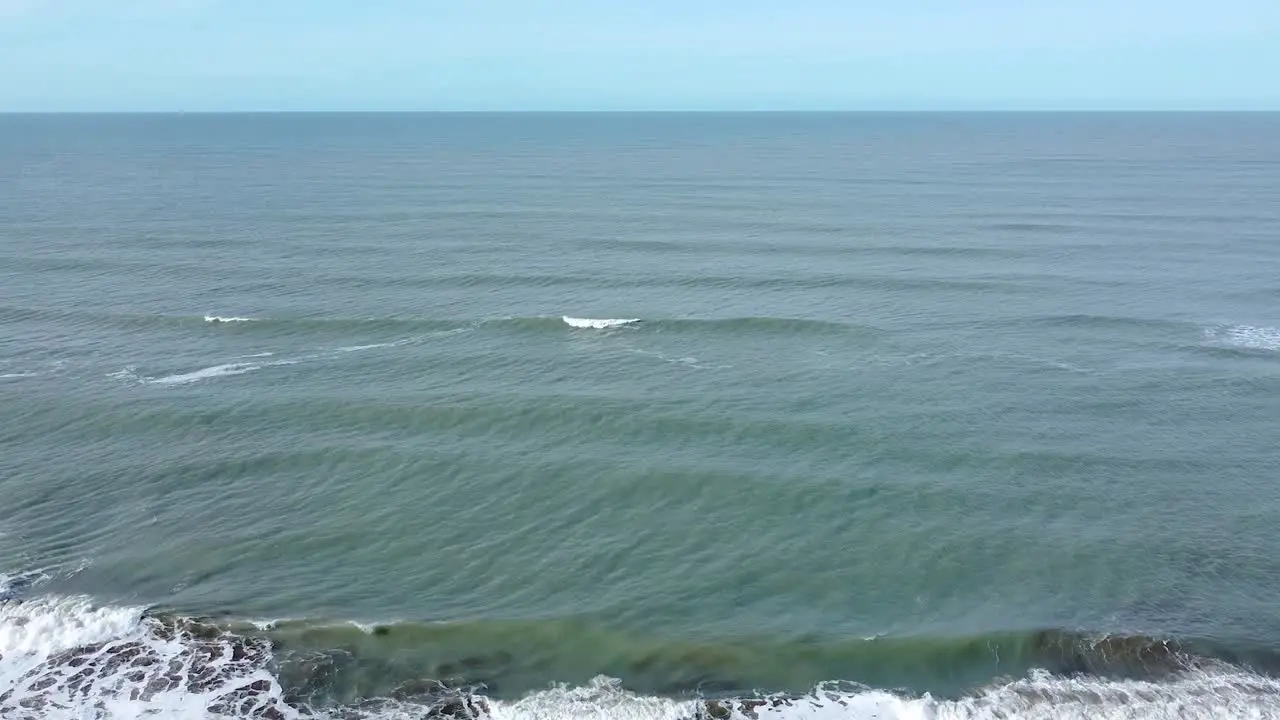 Beautiful shot of the skyline in the Atlantic Ocean  with people passing by on the beach