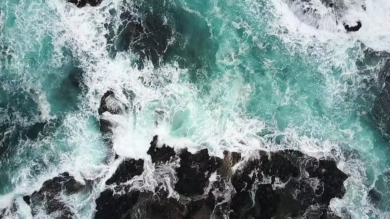 Rising aerial of rocky coastline with waves surging and breaking over rocks Cape Schanck Mornington Peninsula