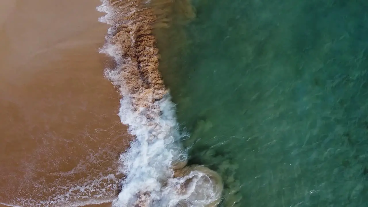 Cinematic shot of water crashing into coast in Hawaii