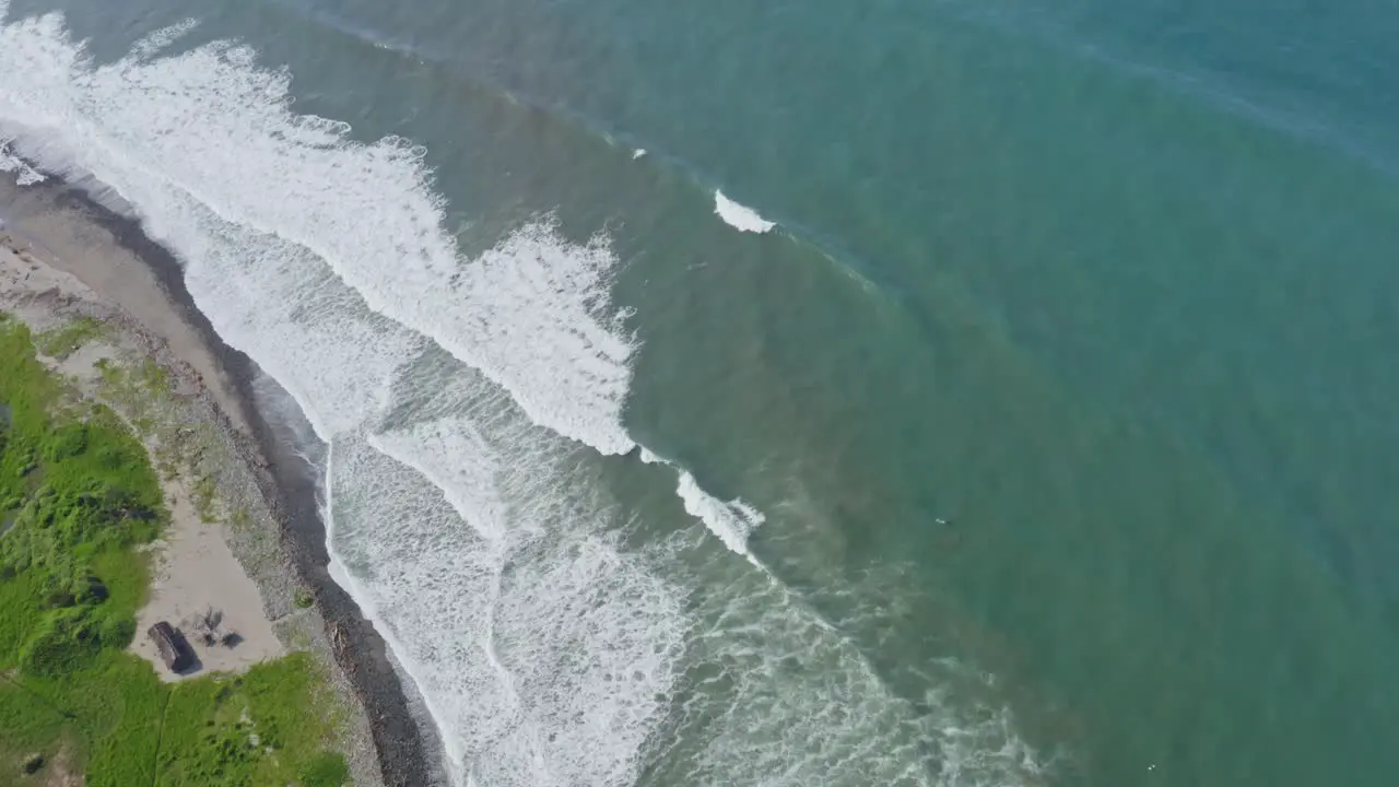 Aerial waves breaking on Pacific Coast ocean whitewater tilt follow