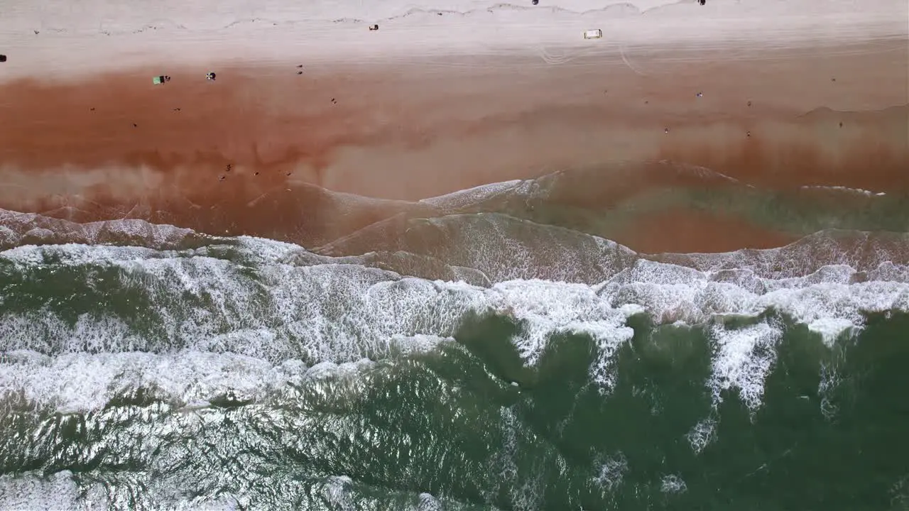 Aerial view of waves hitting the Daytona beach in Florida USA top down drone shot