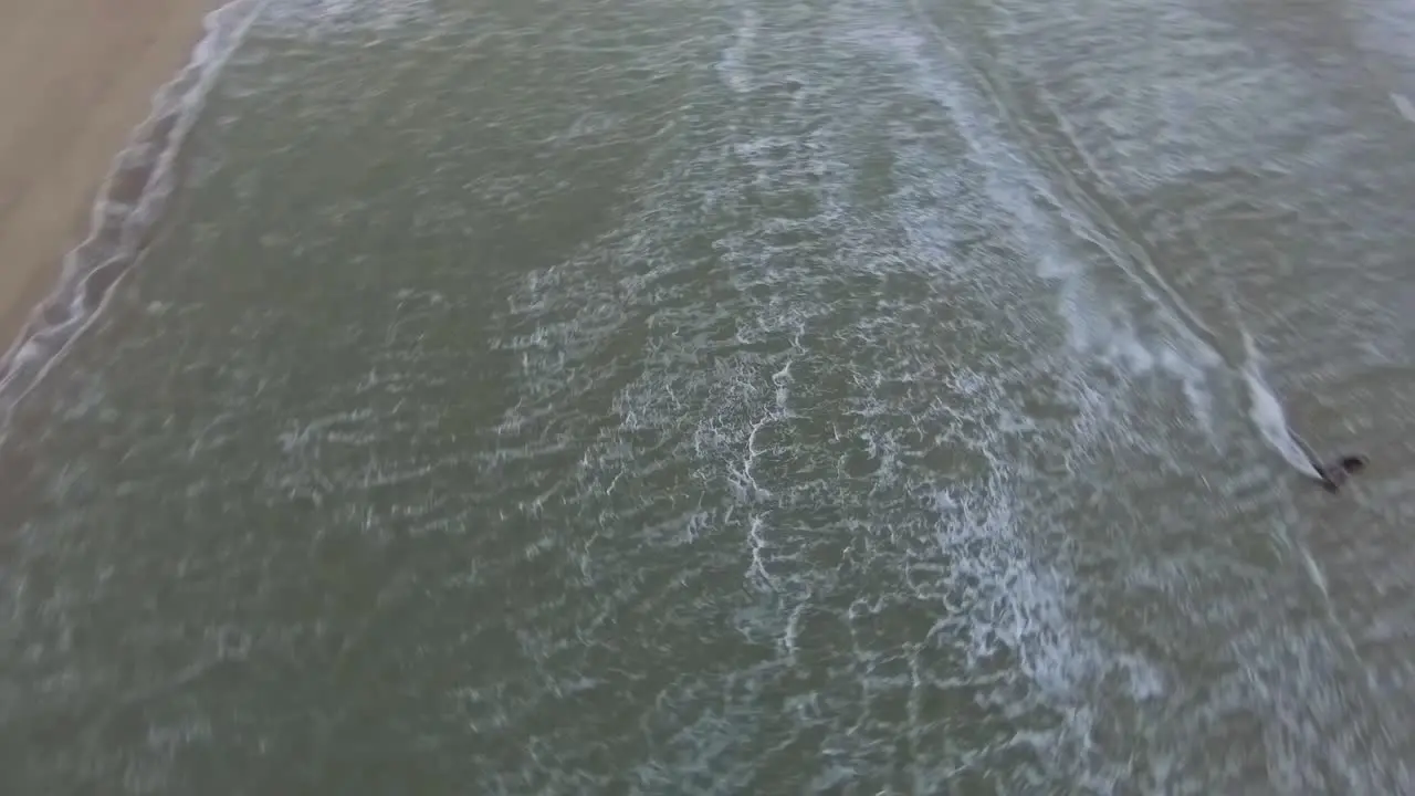 Fast aerial shot of a kitesurfer going through a lagoon in the North Sea