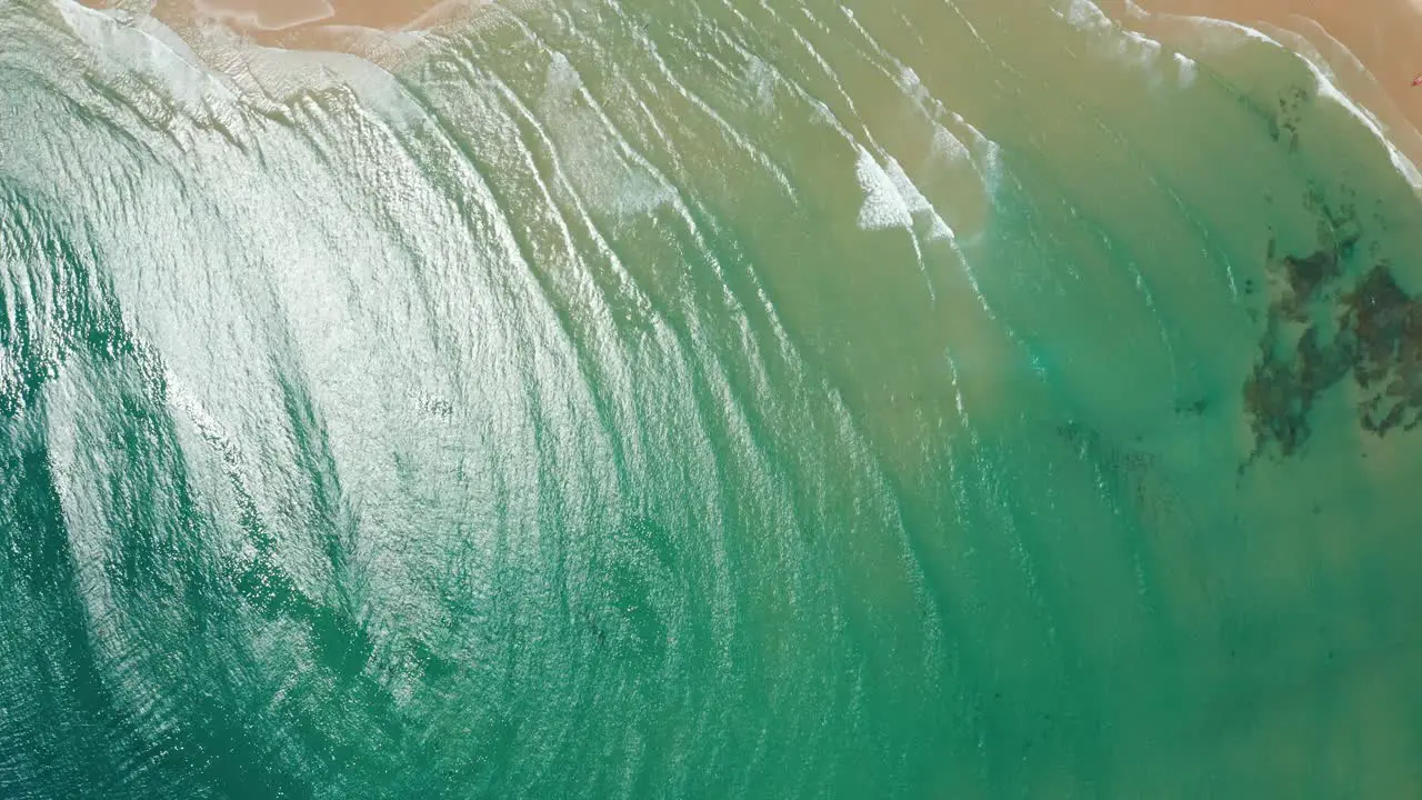 High birds-eye view drone shot over the ocean and a small village in Tofo Mozambique